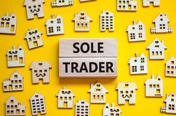 Sole trader symbol. Concept words 'Sole trader' on wooden blocks near miniature wooden houses. Beautiful yellow background. Business, sole trader concept.