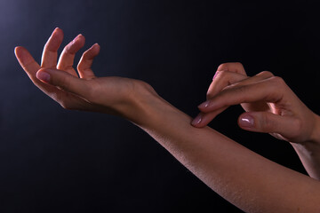 Female hands illuminated by light on dark background