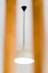 Designed white ceiling lamp through the vertical wood lath, interior and decoration concept