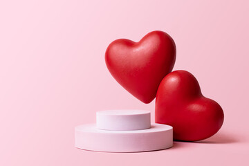 Pink podium with red heart on pastel background to show cosmetic products. Minimal romantic...