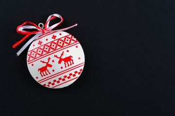 White red christmas minimalist bauble toy in nordic style over black background. Flat lay with copy space. Merry Christmas New Year greeting card with scandinavian ornaments deers