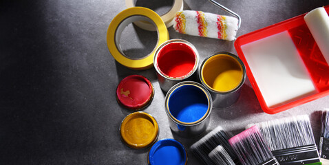 Paintbrushes of different size and paint cans