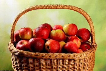 Red apples in wicker basket on the table. Fresh ripe apples in basket