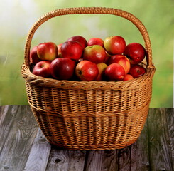 Fototapeta na wymiar Red apples in wicker basket on the table. Fresh ripe apples in basket