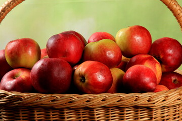 Red apples in wicker basket on the table. Fresh ripe apples in basket