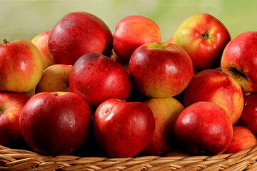 Red apples in wicker basket on the table. Fresh ripe apples in basket