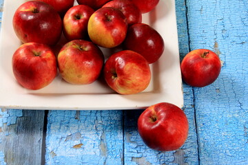 Ripe red apples on a rustic wooden board background. Red juicy apples