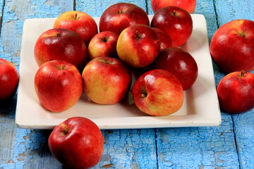Ripe red apples on a rustic wooden board background. Red juicy apples
