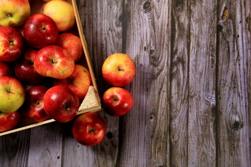Obraz na płótnie Canvas Red apples in a wooden box on a wooden board background. Copy space 