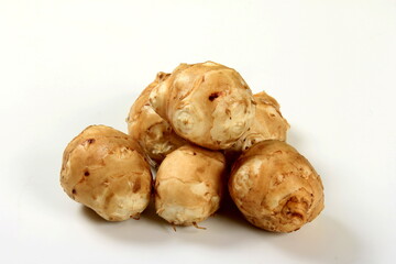 Jerusalem artichoke with white background, close up. Freshly harvested Jerusalem artichoke or topinambur 