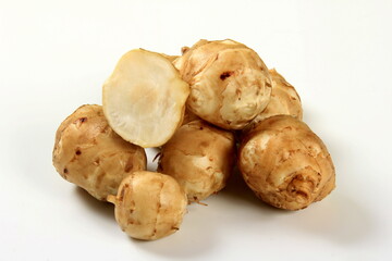 Jerusalem artichoke with white background, close up. Freshly harvested Jerusalem artichoke or...