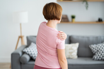 Woman with pain in shoulder at home