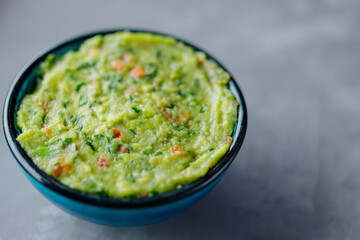 Guacamole bowl on a gray background. Traditional mexican dip sauce guacamole in the bowl. Mexican cuisine. Copy space. Top view