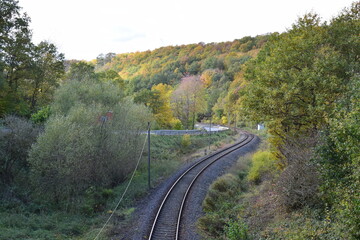 Eisenbahnlinie parallel zur Straße im Herbst