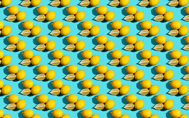Trendy sunlight summer pattern made with yellow lemon slice on bright light blue background. Minimal summer concept. Flat lay.