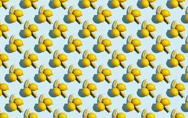Trendy sunlight summer pattern made with yellow lemon slice on bright light blue background. Minimal summer concept. Flat lay.