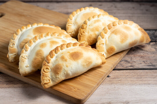 docena de empanadas en tabla de madera