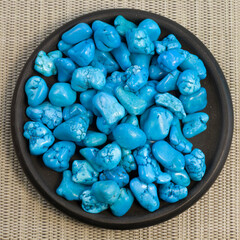 Turquoise jewel gemstones on grey textured background, group of objects