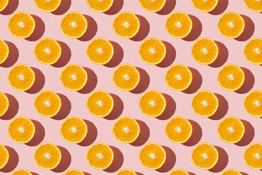 Fruit pattern of fresh ripe slice orange on pink background. Top view, copy space for your text. Fruit composition, healthy concept.