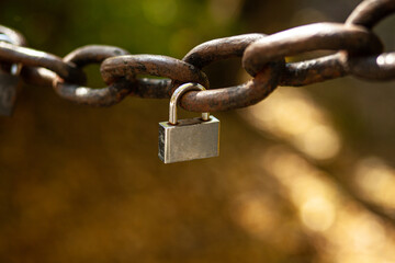 Small padlock on a large vintage chain. A symbol of strong love. Bokeh and blurred back