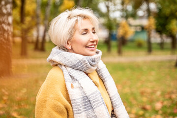Obraz premium Cheerful adult woman on a relaxing walk at park.