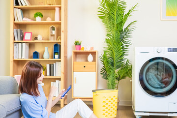 woman use smartphone control washer