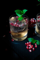 Two summer cocktails with pomgranate, mint and some sugar. flat lay and black background