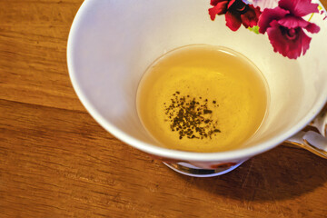 Fragment of a cup with unfinished green tea on a wooden surface