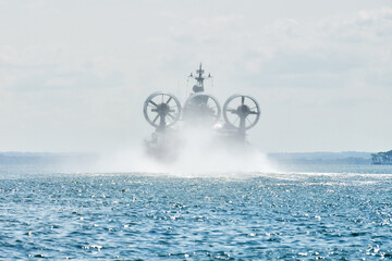 Landing Craft Air Cushion hovercraft flying above water, air cushion sailing splashing sea water