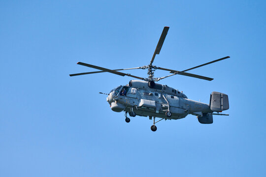 Navy helicopter flying against blue sky background, copy space. One rotary wing aircraft, side view