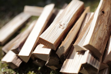 Stack of firewood on the grass at the park. Stack of kindling on the grass in the garden.