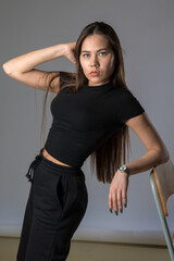 Naklejka premium Model with long hair posing in black suit on white background in studio. Fashion concept