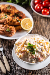 Traditional potato salad with vegetables and mayonnaise as a side dish to fried steaks.