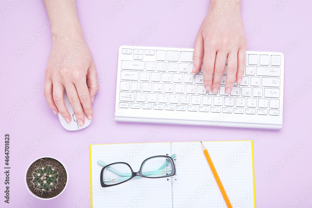Poster female hands typing on computer keyboard with mouse and notepad