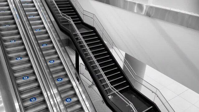 4K black and white footage of empty escalator moving slowly at mall or airport. Infrastructure, disabled people assistance concept.