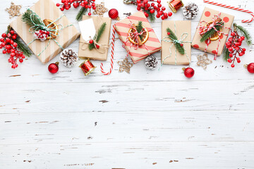 Gift boxes with ornaments on white wooden background