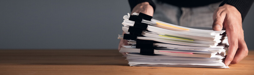 man holding stack of papers