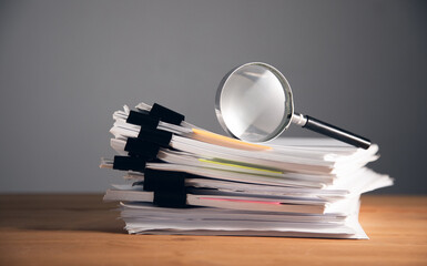 magnifier on stack of papers