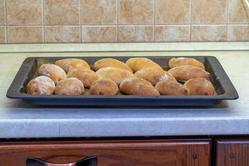 Fresh homemade pies, golden brown, fresh from the oven, are on a baking sheet.