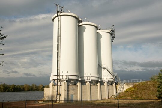 large white industrial storage tanks on a lake in the Belgian Kempense Meren
