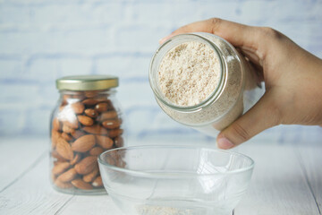 almond powder and almond in a jar on table,