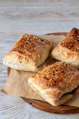 Samsa are Uzbek pies made of puff or plain dough stuffed with meat and onions. Real Uzbek samsa comes from oriental cuisine. Made from lamb and beef. Selective focus. 