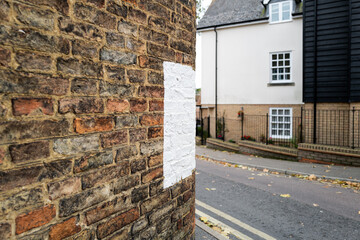 Large painted white marker seen on the side of an old wall to a house. Located on a narrow, sharp...
