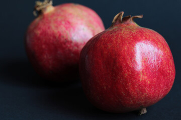 red fresh pomegranate fruit on black background