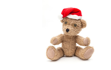 Kleiner Teddybär mit Weihnachtsmütze auf weissem Hintergrund
