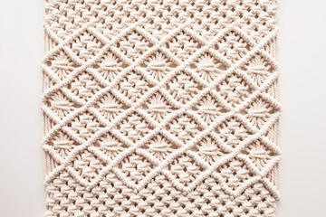 Handmade macrame. Macrame braiding and cotton threads.  Female hobby.  ECO friendly modern knitting DIY natural decoration concept in the interior.  100% cotton wall decoration.
