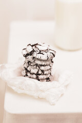 Brownie Cookies, selective focus. Eco friendly food composition with home made chocolate cookies on a white paper and bottle of milk on a white table. Hande made natural sweet pastries
