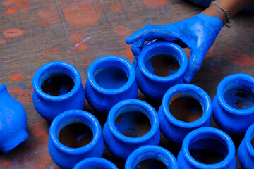 Pune, India, 22 October 2021: A Small girl prepares earthen pots ahead of Hindu Diwali festival.