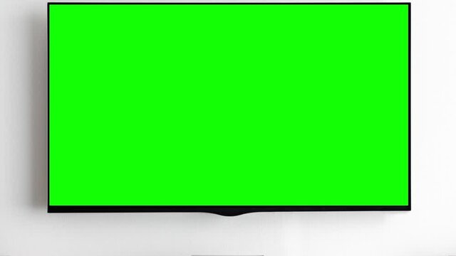 TV with green screen on white wall in modern interior. Zoom in. Chroma key