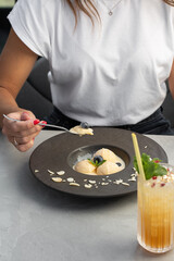 Girl enjoying ice cream. Close Up Still Life of Scoops of Vanilla Ice Cream with blueberry on Modern black Plate on gray background